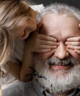 une petite fille cache les yeux de son grand père