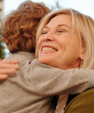 un petit-fils et sa grand-mère a coté d'un sapin de noel