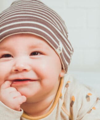 Bébé souri avec une doigt dans la bouche